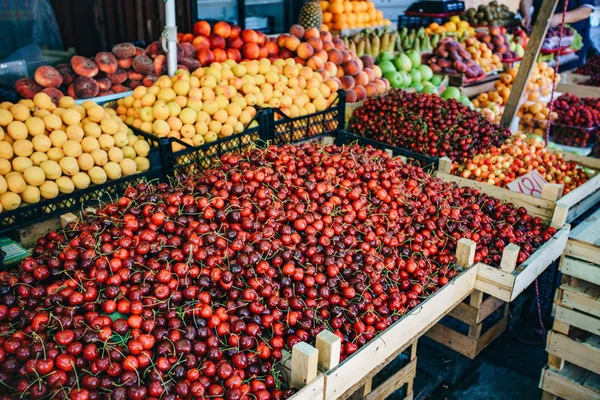 Fruta fresca en el mercado. Albaricoques, melocotones, cerezas, manzanas — Foto de Stock