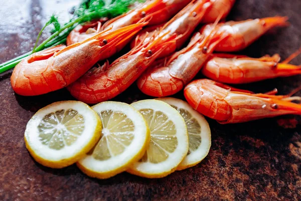 Camarones frescos con limón y eneldo en la mesa roja . — Foto de Stock