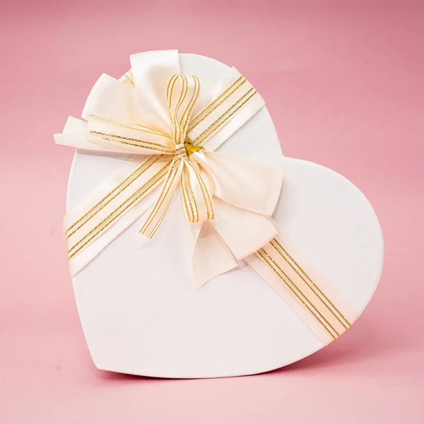 Caja de regalo en forma de corazón sobre fondo rosa — Foto de Stock