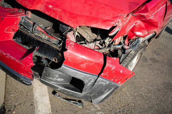 Kırmızı arabanın önü yolda kazara hasar gördü. — Stok fotoğraf