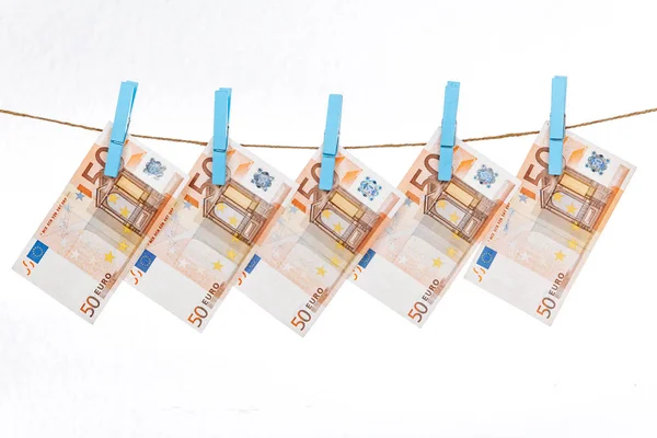 Euro-Banknoten sind mit blauen Wäscheklammern an einem Seil auf weißem Hintergrund befestigt — Stockfoto