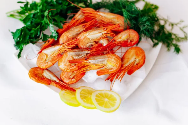 Camarones en un plato con limón y eneldo. Fondo blanco — Foto de Stock