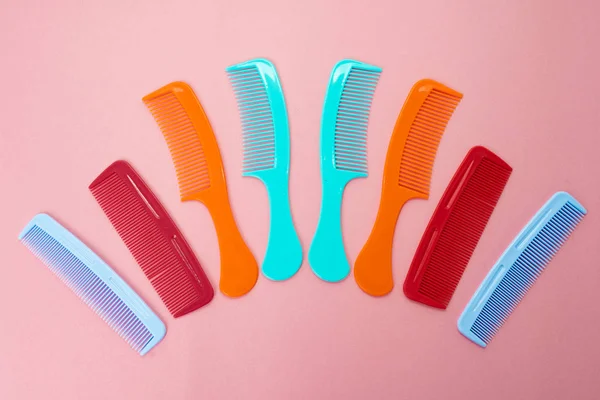 Various colored brushs and combs for hair on pink background. co — Stock Photo, Image