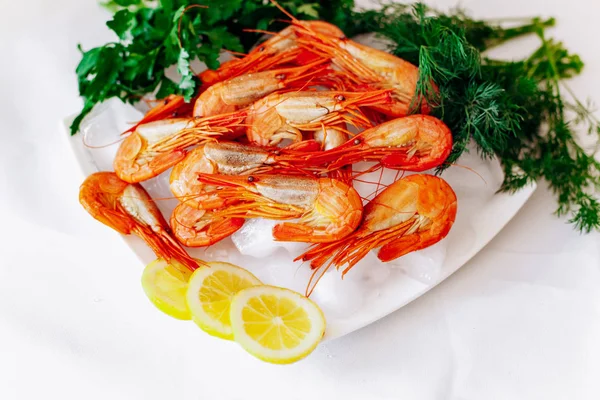 Camarones en un plato con limón y eneldo. Fondo blanco — Foto de Stock