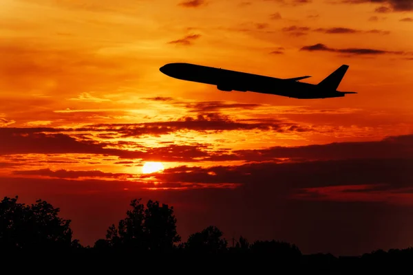 Samolot lata po zachodzącym słońcu. Samolot na niebie o wschodzie słońca — Zdjęcie stockowe