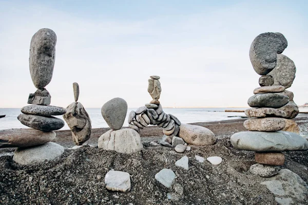 海の近くのビーチでの石の数字。海の背景と石像. — ストック写真