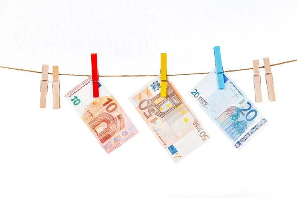 Eurobankovky jsou připevněny kolíky různých barev na provaze na bílém pozadí — Stock fotografie
