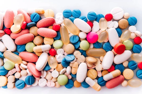 Pilules de médecine pharmaceutique assorties, comprimé. Pilules fond. tas de divers comprimés de médecine assortis et des pilules de différentes couleurs sur fond blanc. Soins de santé. Vue du dessus — Photo