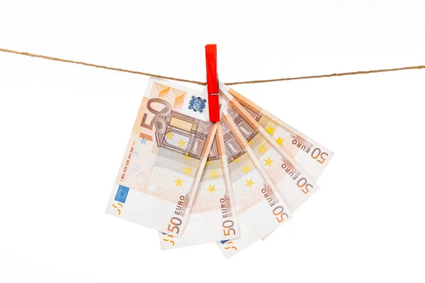 Az eurobankjegyeket piros ruhacsipeszekkel fehér alapon kötélhez erősítik. — Stock Fotó