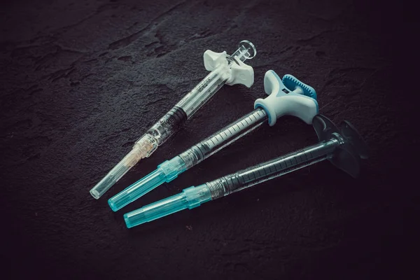 Cosmetology  injections. Plastic syringe on black background. M — Stock Photo, Image