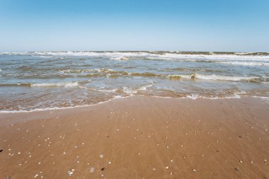 Kumlu sahilde denizin yumuşak dalgası. Deniz kıyısında.