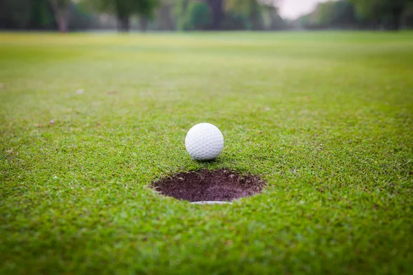 グリーン メドー ゴルフ ボール カップの唇にゴルフ ボール — ストック写真