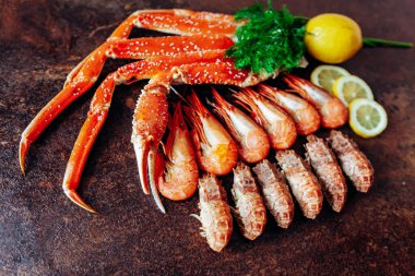 Kırmızı arka planda yengeç, karides, bitki ve limon kompozisyonu
