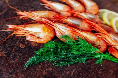 Kırmızı masada limonlu ve dereotlu taze karides..