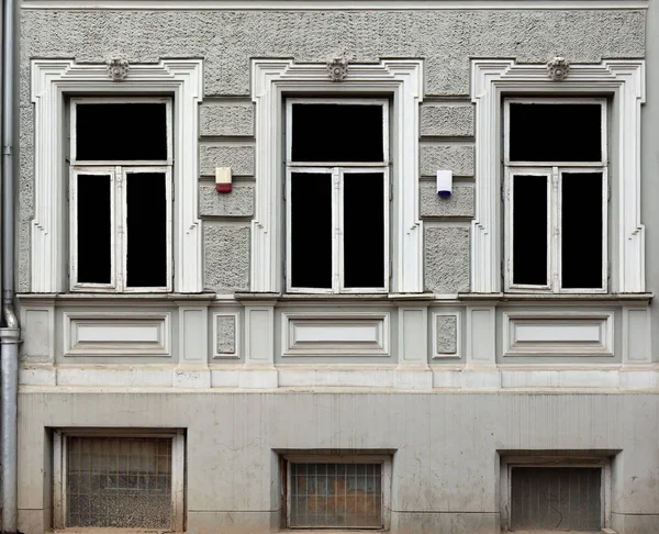 Três janelas com molduras de pedra decorativas na casa estilizadas — Fotografia de Stock