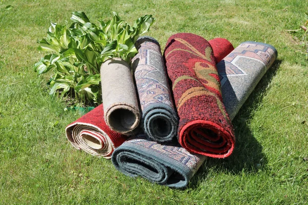 En un césped verde rural sucia alfombras sintéticas casa vieja mentira —  Fotos de Stock