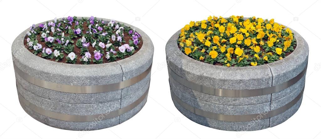Two big street  flowerpots are made of gray granite in the form 