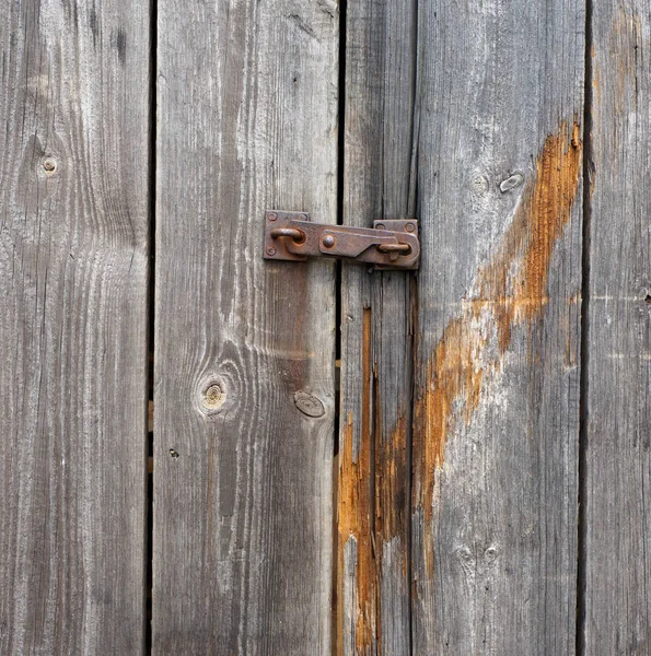 Kleine eiserne rostige Klinke an einer schimmelnden Holztür — Stockfoto