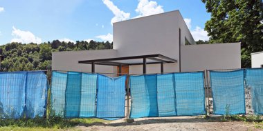 Metal kafes ve mavi sentetik katranlı muşamba yapılmış bir çit