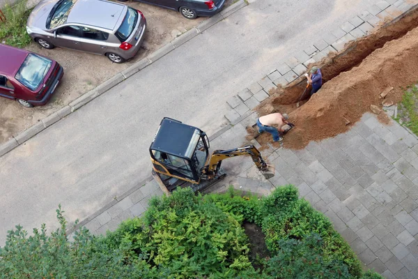 Aerial view on workers who dig a trench — Stock Photo, Image