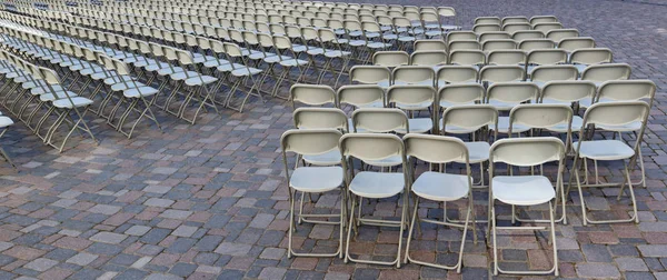 Hundreds of folding chairs are installed on the granite square