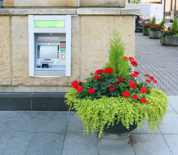 FLowerpot con geranio en flor cerca de ATM — Foto de Stock