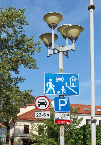 Road signs of the red urban automotive zone hang on a street lam — Stock Photo, Image