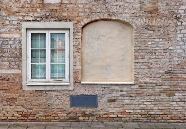 Fenêtres de sous-sol incurvées aveugles dans la vieille maison de briques rouges . — Photo