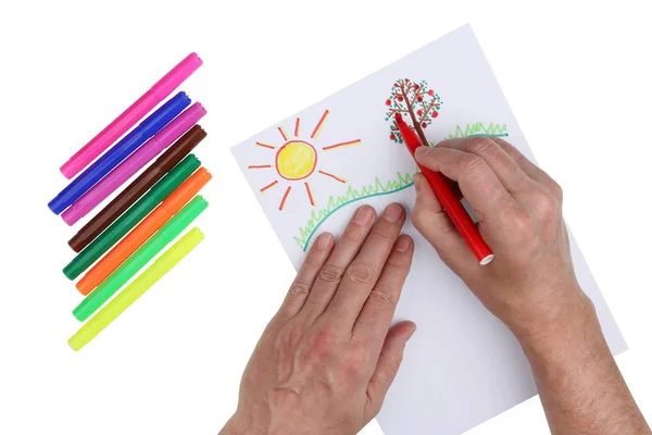 Grandpa paints the sun and apple tree with felt-tip pens for his — Stock Photo, Image