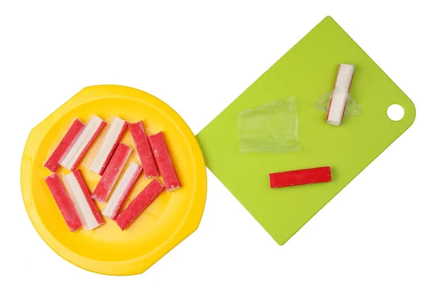 Cleaning  the red frozen crab sticks from parchment paper. — Stock Photo, Image