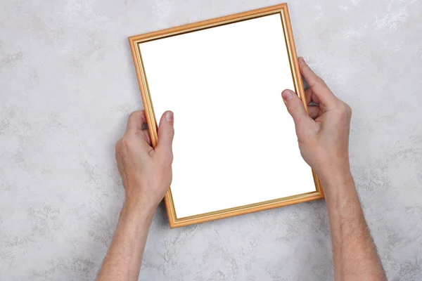 The old man tries to hang a wooden frame with a photograph on th — Stock Photo, Image