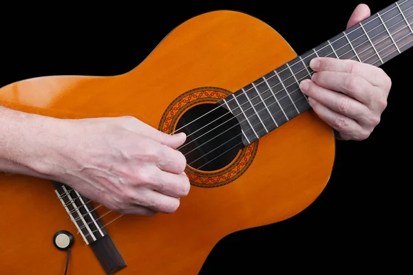 An elderly man with nervous hands plays a classic guitar retro m
