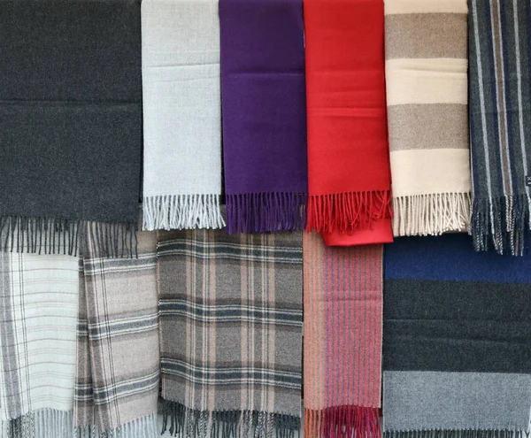 Scarves of different colors and styles with fringe at the ends h — Stock Photo, Image
