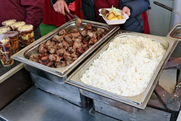 Com movimentos rápidos, o comerciante de comida de rua coloca pedaços de fr — Fotografia de Stock