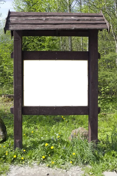 On the spring forest  glade there is a aged brown  wooden stand — Stock Photo, Image