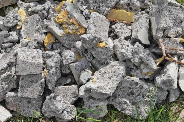 Lappar av brutet slagg konkreta låg på gräset. — Stockfoto