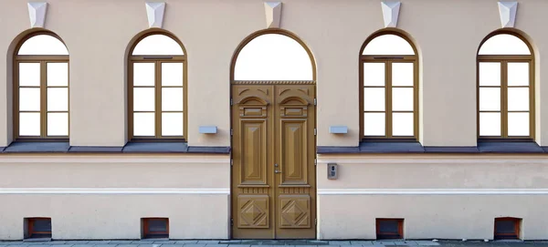 Четыре окна и деревянная дубовая дверь в отремонтированном общественном здании — стоковое фото