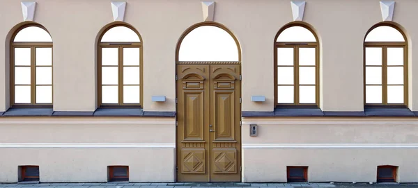 Vier Fenster und eine hölzerne Eichentür im sanierten öffentlichen Gebäude — Stockfoto