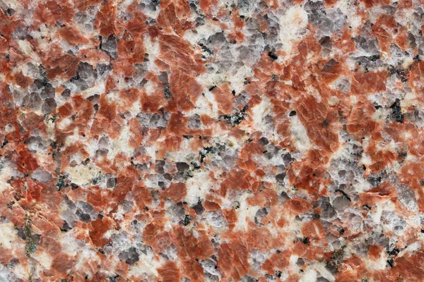 Textura granular de uma pedra de granito vermelho polido — Fotografia de Stock