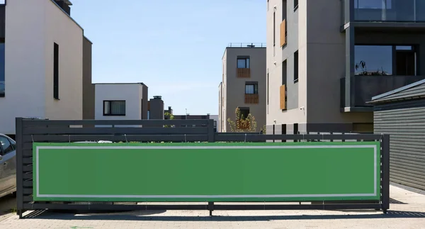 Large green advertising banner set on a wooden fence in a new re — Stock Photo, Image