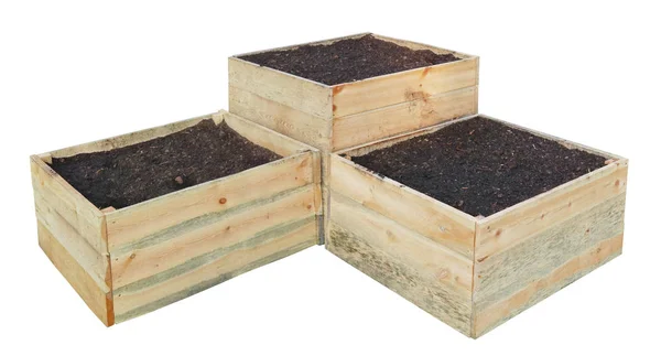 Drie nieuwe houten kisten gevuld met compost en aarde voor de teelt — Stockfoto