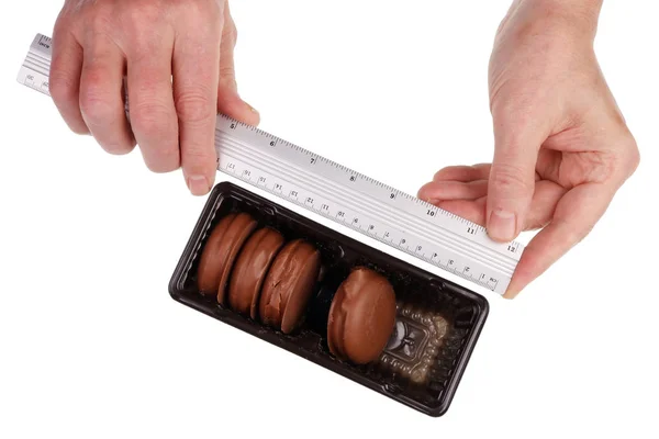 一位工厂技术人员在一家工厂里检查了巧克力甜甜圈的大小。 — 图库照片