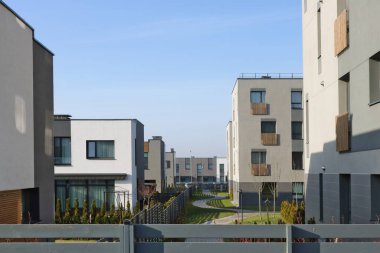  Genç aileler için düşük maliyetli daireleri olan yeni modern Avrupa modüler evleri. Ahşap çitler değişik konfor ve maliyetlerin olduğu alanları sınırlıyor. Doğal renkler sade manzara