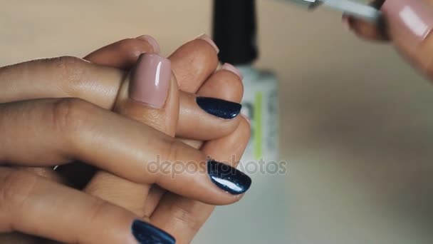 Ženské manikérka ruka uvedení tmavě modrý magnetický lak na nehty v kosmetickém salonu