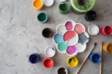 Gri desen arkaplanına farklı renkler çizmek için Gouache. Gouache kutuları rastgele yerleştirilmiş. Arkaplan gri desen fırça darbeleri