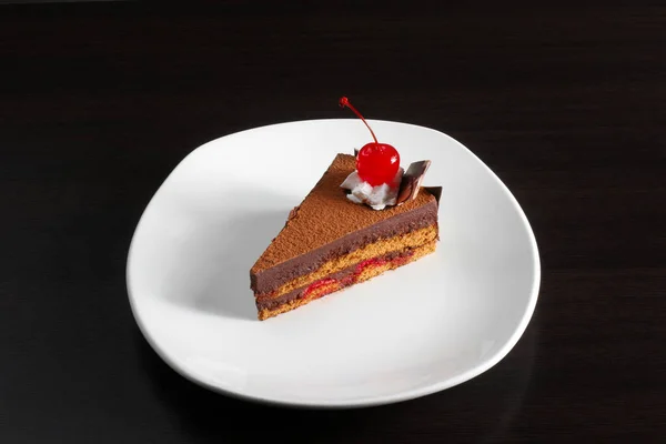 Un morceau de gâteau avec une cerise rouge Photo De Stock