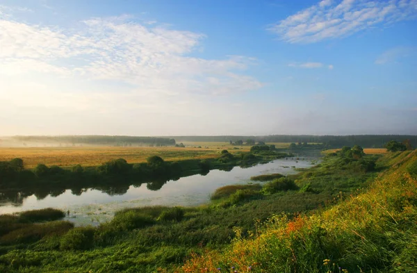 Paisagem rural com um rio na hora de verão Fotografia De Stock