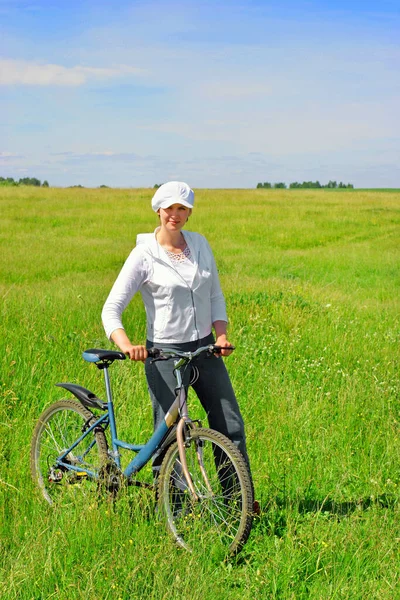 Mujer joven con una bicicleta Imagen de archivo