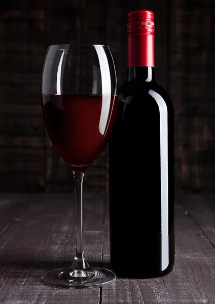 Bottle and glass of red wine on wooden board — Stock Photo, Image