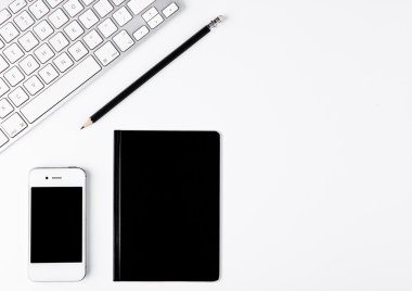 Siyah kalem ve telefon üstünde okul sırası ile beyaz klavye
